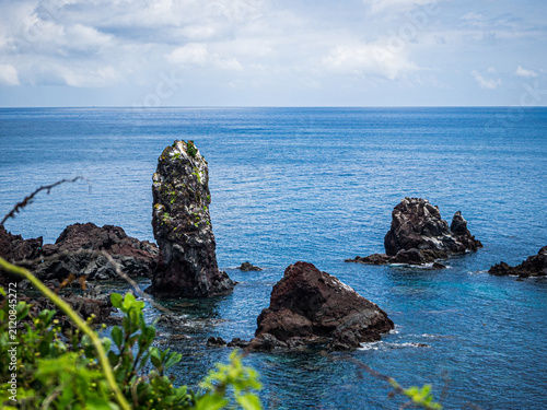 JEJU, SOUTH KOREA - JULY 30, 2026: Volcanic sea stacks rising from the sea at Seopjikoji, a rugged basalt coastline on Jeju Island.