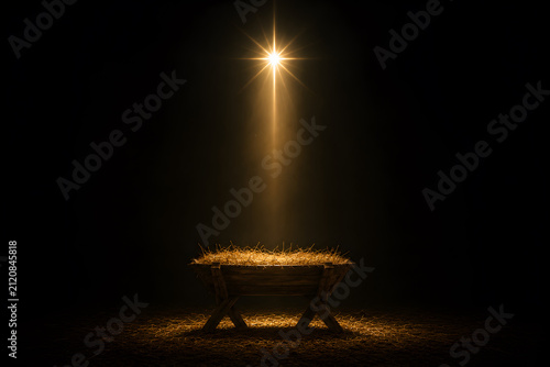 A nativity scene with empty manger and a bright star at night with Christmas concept