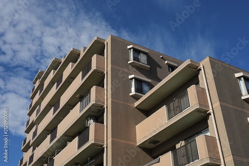 鉄筋コンクリートの中規模マンションと青空