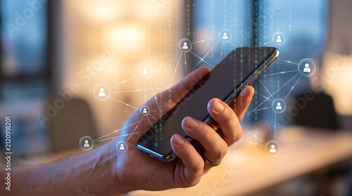 Hand holding smartphone with digital network overlay showing interconnected people icons and binary code representing global communication and modern connectivity concepts