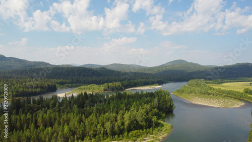 Foto Drone shot of river in taiga surrounded by mountains and dense forest in summer