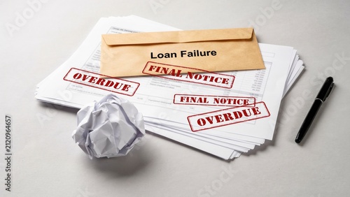 Fotografie Loan failure envelope resting on financial documents featuring red overdue stamp