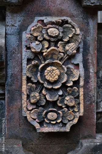 Traditional Balinese stone carving featuring a highly detailed floral motif