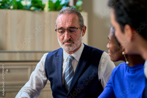Serious Senior Caucasian Businessman in Professional Meeting, Concerned Mature Male Executive in Office Discussion, Corporate Problem Solving Scene.