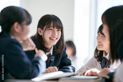 Obraz na płótnie 制服を着て笑顔で楽しそうに話し合う日本人の女子中学生グループ