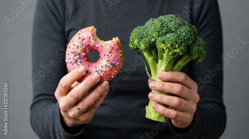 person holding bitten pink donut sprinkles head fresh green broccoli