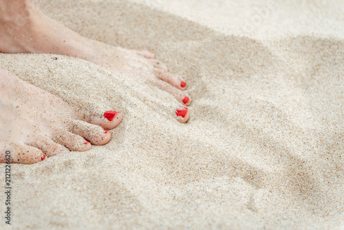 Weibliche Zehen barfuß im warmen Sand am Strand – entspannter Sommerurlaub