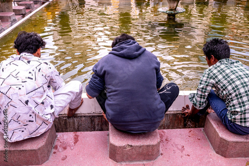 Fotografie Three men performing ablutions before prayer at the Jama Masjid Khairuddin Grand Mosque in Amritsar, Punjab, India