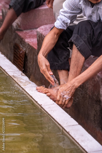 A man washes his feet with water from a basin at the Jama Masjid Khairuddin mosque in Amritsar, Punjab, India.