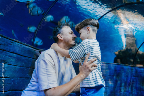 Father and son look at the fish