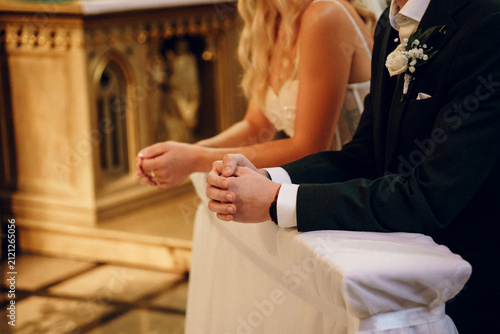 Картината върху платно Bride and groom praying at church altar