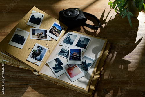 Obraz na plátně Collection of old photos and camera on a wooden table