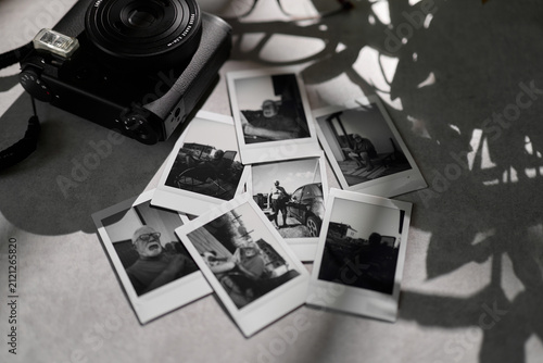 фотографія Old black and white photos displayed near a camera on a table