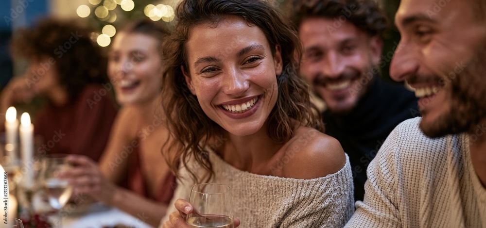 Obraz premium A vibrant holiday gathering with joyful guests sharing stories amid colorful decorations and cozy ambiance.