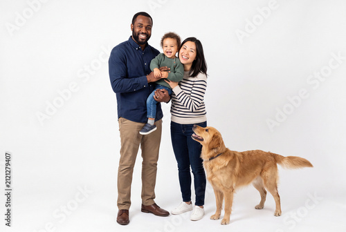 Happy Interracial Family with Daughter and Golden Retriever in Studio