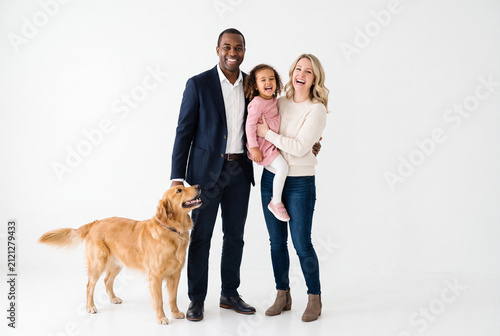 Happy Interracial Family with Daughter and Golden Retriever in Studio