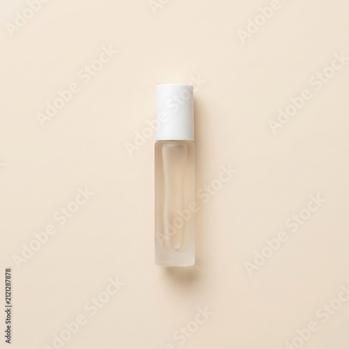 Small glass roller bottle with white cap for essential oil or perfume on a beige background. personalized perfume vial