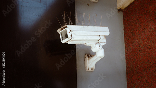 CCTV, camera, security, surveillance, old dirty white security camera with bird spikes mounted on wall