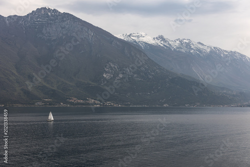 Sailboat on Lake Garda with Snow-Capped Mountains, Italy