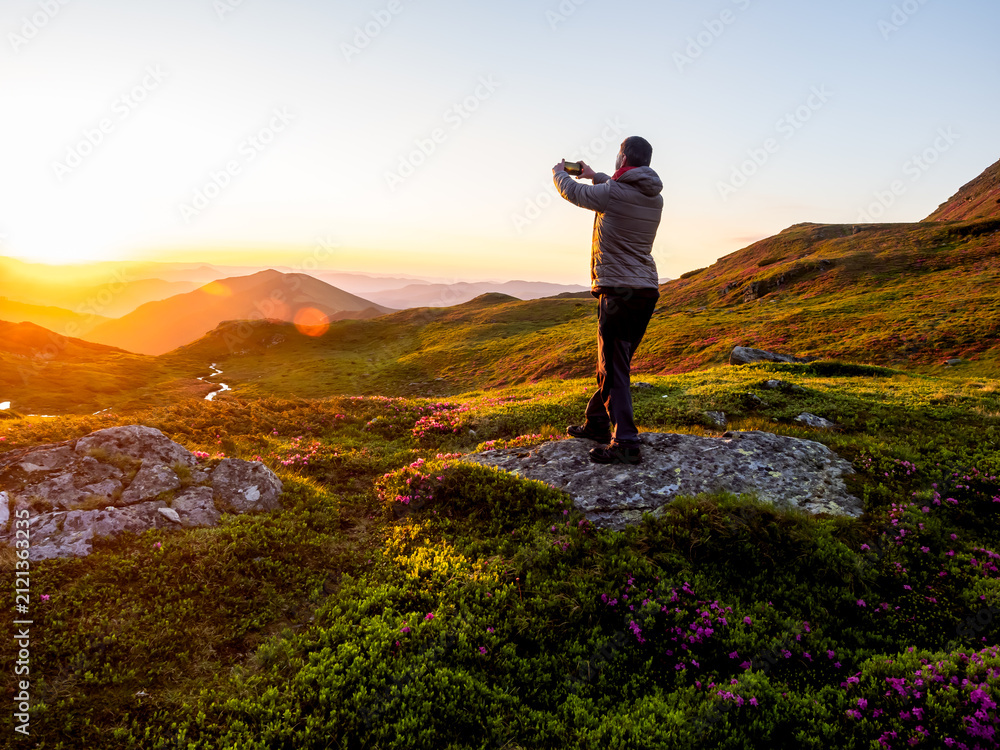 Obraz premium Hiker Photographing Sunrise With Smartphone in Rodnei Mountains