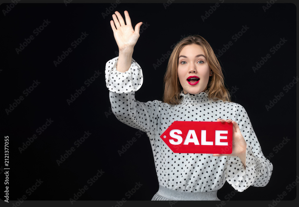 Fototapeta premium Kırmızı indirim işareti gösteren heyecanlı güzel kız, alışveriş ve indirim konsepti, koyu arka plan