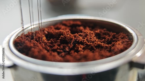 Tool with needles aerating coffee grounds in portafilter