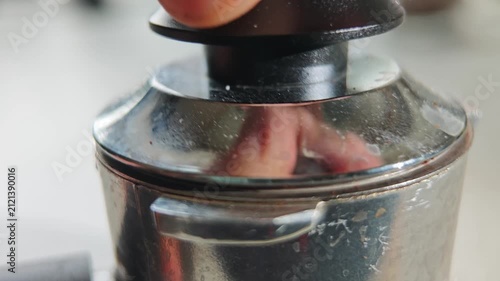 Tamping coffee grounds in portafilter for espresso machine