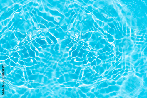 Blue water with ripples on the surface. Defocus blurred transparent white colored clear calm water surface texture with splashes and bubbles. Water waves with shining pattern texture background.
