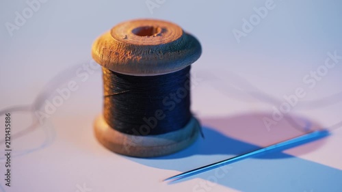 Black thread with needle on white table
