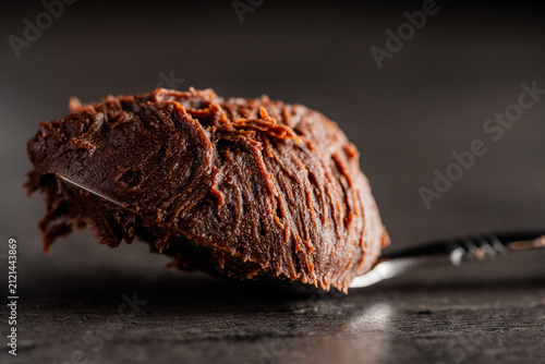 Fotografie spoonful of chocolate icing on a kitchen bench