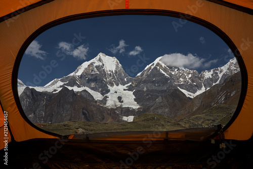 Obraz na płótnie Framed by the entrance of a mountaineering tent at Carhuacocha Camp, the imposin