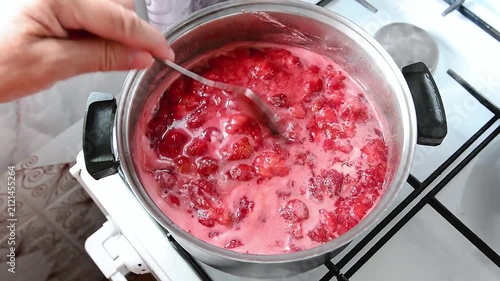 Making strawberry jam in a saucepan on a gas stove