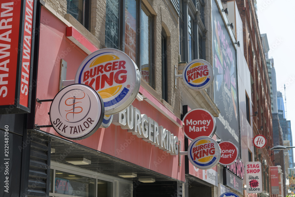 Fototapeta premium wall-mounted round projecting signs of Silk Tailor, Burger King, Money Mart, on Yonge St, Toronto