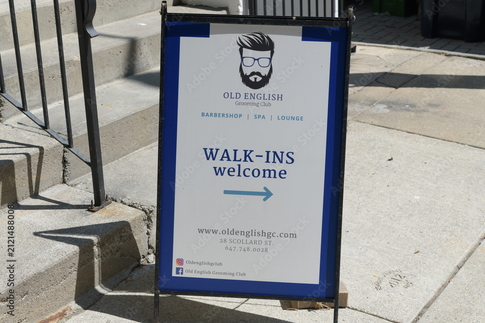 Fototapeta premium a-frame sidewalk sign outside Old English Grooming Club, a high-end luxury men's barbershop and social lounge, located at 28 Scollard St, Toronto