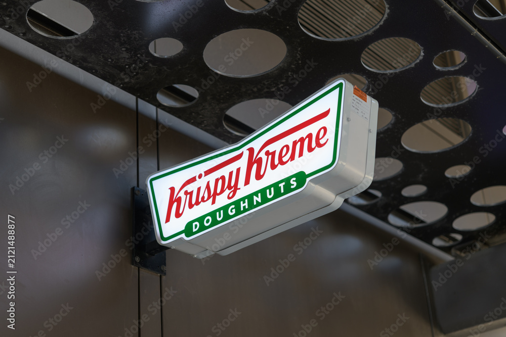 Fototapeta premium suspended logo shaped sign outside Krispy Kreme Café, a donut shop chain, located here at 105 Dundas St E, Toronto