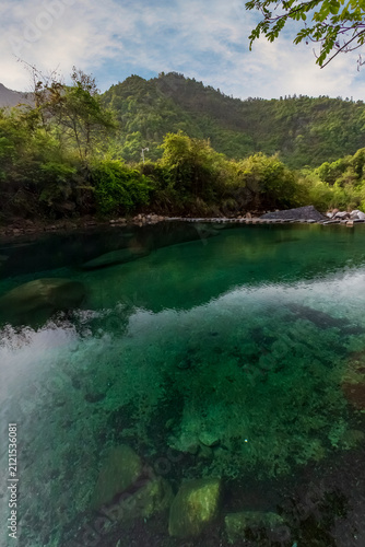 Bild auf Leinwand Guniujiang Emerald Pool Reflection: Lush Forests Frame Serene Valley Waters, Mir