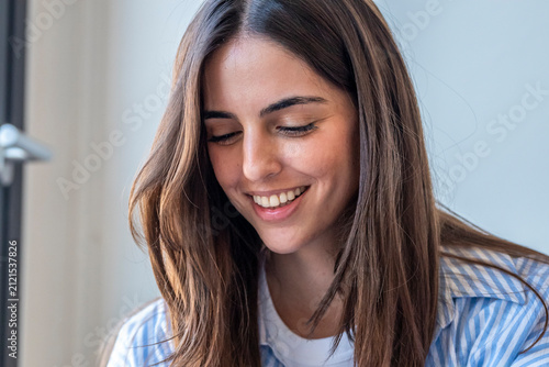 Fotografie Young brunette woman smiling broadly with closed eyes, expressing happiness and