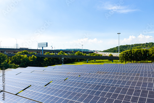 Solar panels beside transport interchange and green hills