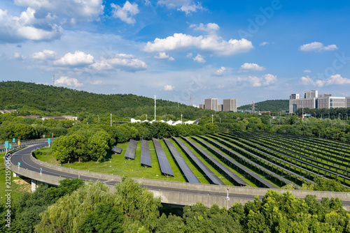 Photovoltaic panels beside road in green suburb