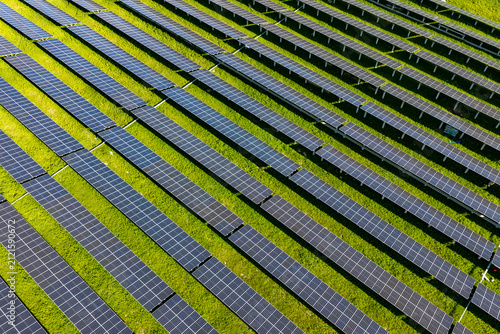Geometric rows of solar panels on green grass