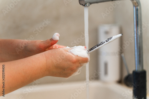 Konstfotografi Hands washing table knife with foam in the kitchen