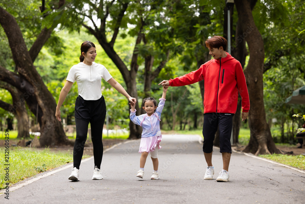 Obraz premium Parents are here reate perfect day for childrent. Father and mother hands and raise her up and walk. exercising and walking together in city park summer. healthy lifestyle in nature. family bonding