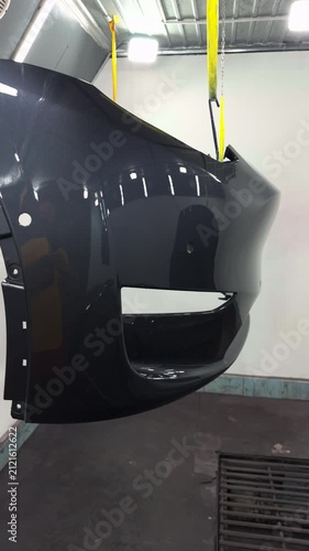 Automotive bumper undergoing a high-quality paint finishing process in a clean workshop