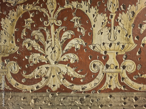 partial view of a beautiful decorative fresco full of holes