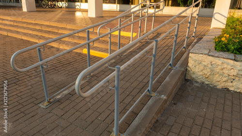 Canvastavla Angled perspective of concrete wheelchair ramp featuring double metal handrails