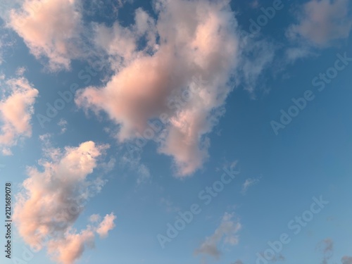 Pink sunset clouds in blue sky with copy space