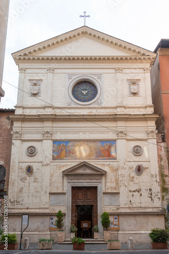 The elegant facade of the Church of Spirito Santo dei Napoletani in Via Giulia, Rome, Italy, featuring a rose window and frescoed portal