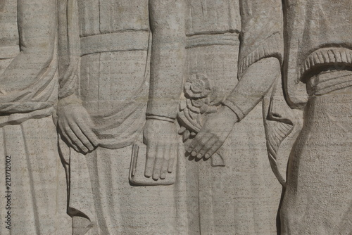 close-up of hands and draped figures in a carved stone relief in rosario argentina