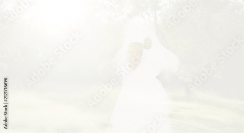 Abstract soft focus background of green grass and trees in bright, ethereal light, perfect for design templates