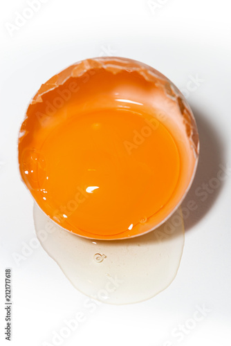 half shell with chicken egg on white background, vertical